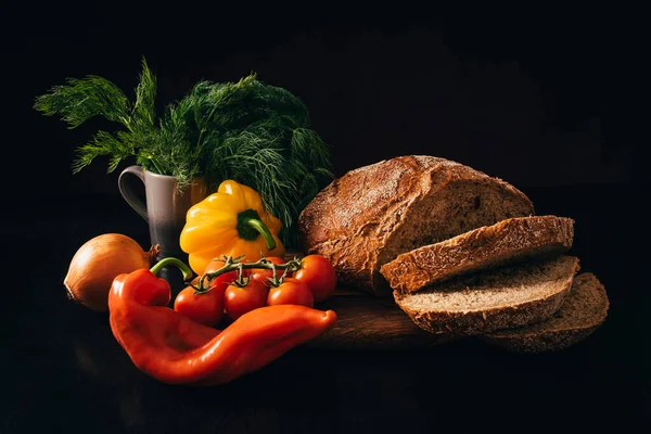 Sebzeler ve arka planda dilimlenmiş ekmek.