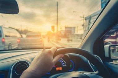 Arka plan kullanımı için gündüz vakti araba kullanan insanların klasik ton görüntüsü. (içeriden fotoğraf çek sürücü eline odaklan)