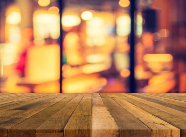 Arkaplan kullanımı için ahşap masa ve bulanık restoran yüzeyine seçici odaklı ton görüntüsü.
