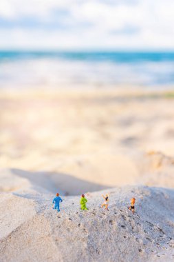 minifigure bebek fikir görüntüsü ile Kum Plajı üzerinde çalışan dört runner arka planda gün zamanında güzel deniz bulanıklık. (dikey)