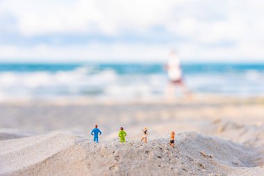 minifigure bebek fikir görüntüsü ile Kum Plajı üzerinde çalışan dört atlet bulanıklık güzel deniz gün zaman arka planda.