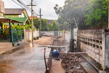 Zavallı sokak İnşaat ve düzeltme zemin Bodrum sonra boru hattından sızdıran musluk suyu Çeşmesi görüntüsünü.