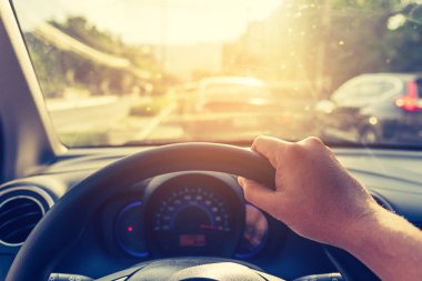 Arka plan kullanımı için gündüz vakti araba kullanan insanların klasik ton görüntüsü. (içeriden fotoğraf çek sürücü eline odaklan)