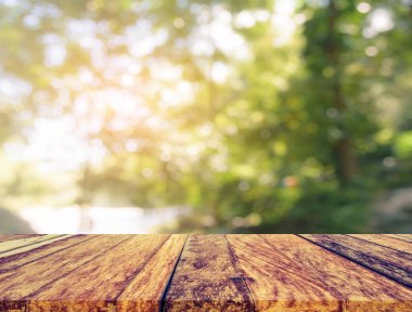 wood table and blur image of tree.