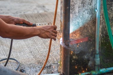 kaynakçı adam kaynak makinesi ile kapı düzeltmek.