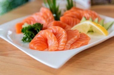 Taze somon sashimi beyaz çanak dilimlenmiş.