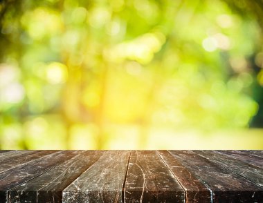 Ahşap masa ve yeşil bokeh resmi.