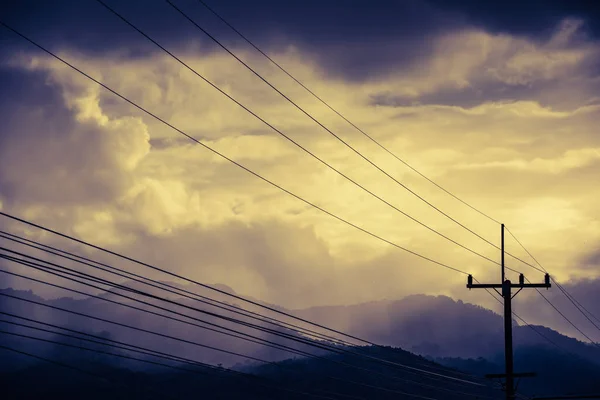 Bulutlu gökyüzü ile yüksek gerilim elektrik teli. — Stok fotoğraf