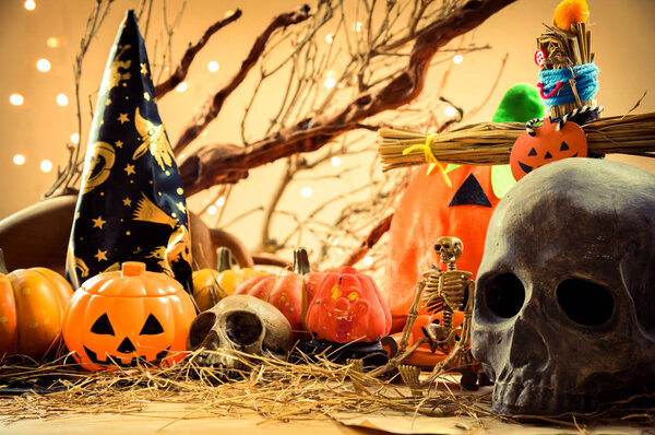 Halloween pumpkin and variety of ornaments on wood table.