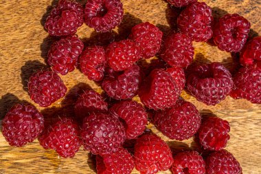 Taze sulu ahududu ahşap arka planda makroyu kapat. Doğa geçmişi. Taze meyve..