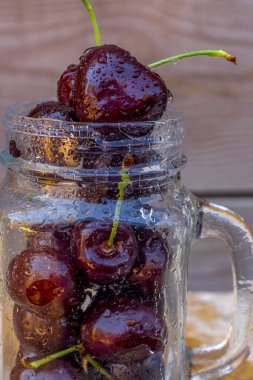 Cam bardakta kırmızı, ıslak, soyut bir kiraz. Güzel ışık. Işık efekti. Makro