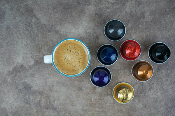 Tazza di caffè su sfondo scuro con capsule di caffè. Cibo dolce. Colazione sana. — Foto Stock