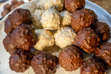 Beyaz arka planda siyah, beyaz ve sütlü çikolata. Makro kapaklı Fransız çikolatası. Taze organik fındık.