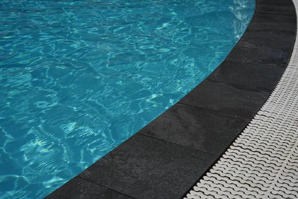 Bord piscina abierta, agua y textura de mármol negro . —  Fotos de Stock