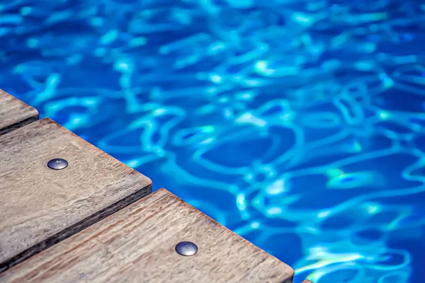 Foco suave. Bord piscina abierta, agua y textura de madera natural . —  Fotos de Stock