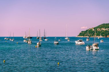 Aziz Jean-Cap Ferrat, Fransa. 16.07.2020. Akdeniz kıyısında akşam deniz manzarası, yatlar ve motorlu tekneler. Spor geçmişi. Deniz gemisi. Gökyüzü bulutları. Tatil gezisi.