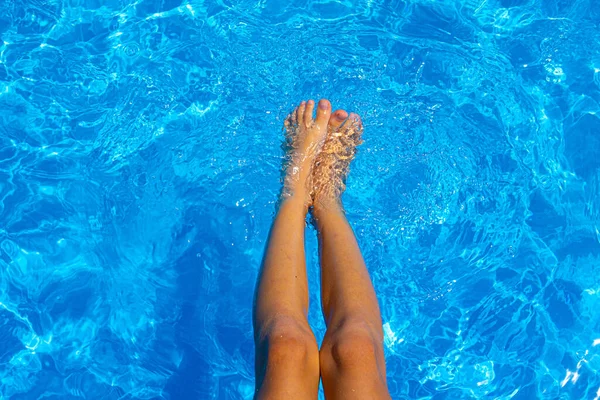 孩子的脚在游泳池里。软焦点背景。暑假。豪华生活方式设计的漂亮特写。度假，度假。护肤蓝底童脚池的漂亮特写. — 图库照片
