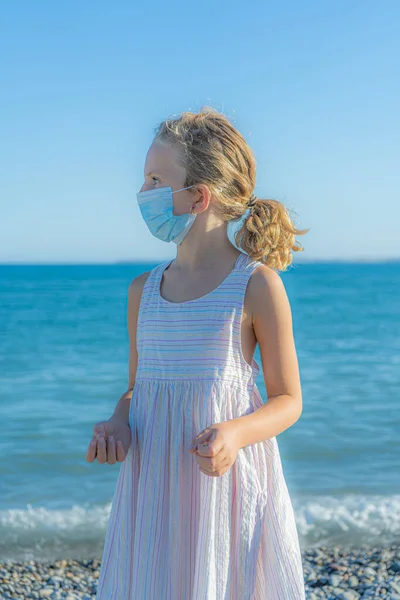 Meisje op het strand met een beschermend masker — Stockfoto