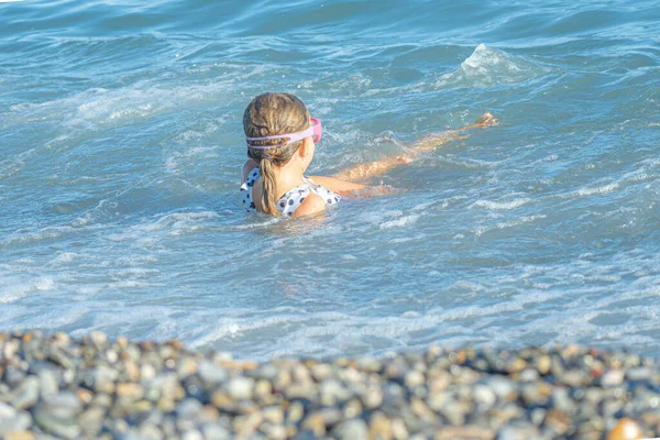 Menina nada nas ondas na costa — Fotografia de Stock