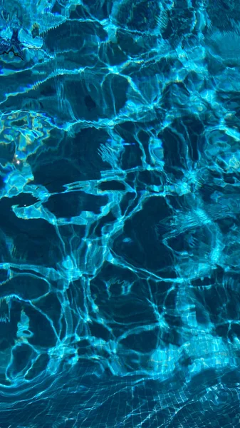 Textura del agua de la piscina sobre un fondo azul. —  Fotos de Stock