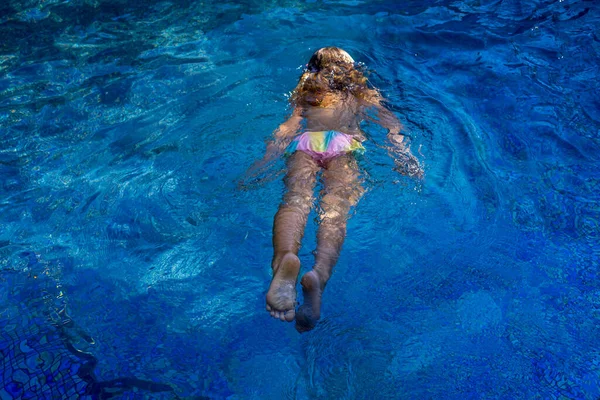 Menina nada na piscina azul . — Fotografia de Stock