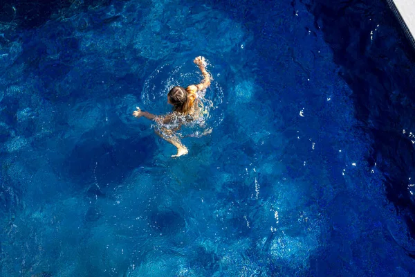 Menina nada na piscina azul . — Fotografia de Stock