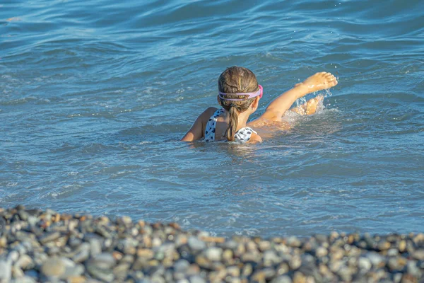 Petite fille nage dans les vagues sur la côte — Photo