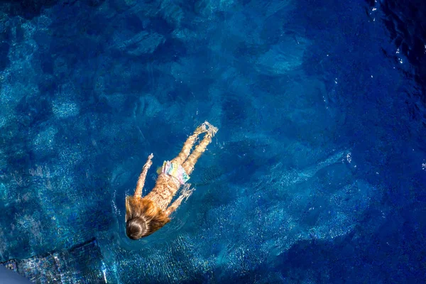 Concentração suave. Menina nada na piscina azul . — Fotografia de Stock