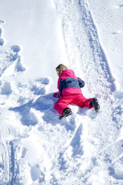 Genç kız bir kar dağından geriye doğru kayıyor.