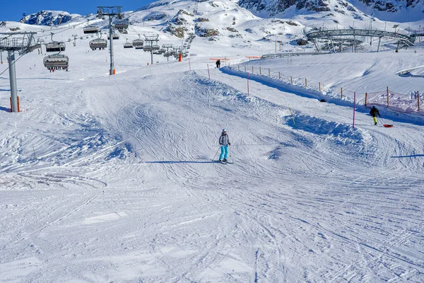 Alpe DHuez, Frankrike 30.12.2019 Linbanelyftens kabinbakgrund. Vacker vinter vacker utsikt över bergen. Kvinnlig skidåkning utför — Stockfoto