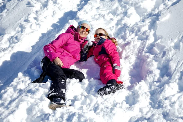 La bambina e sua madre giocano all'aperto nella soleggiata giornata invernale. Concetto vacanze invernali attive. — Foto Stock