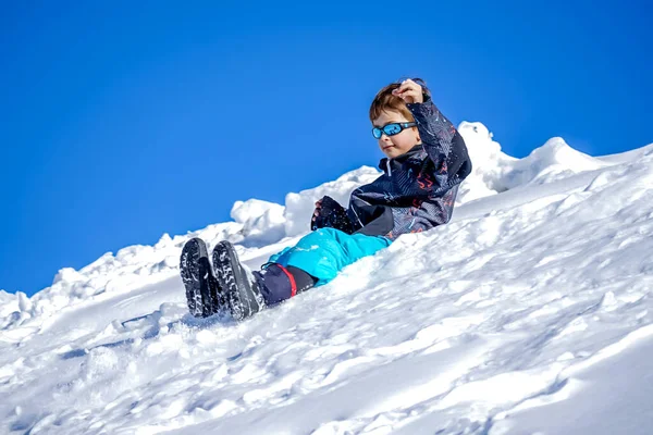Jongen glijdt naar beneden op de Sneeuwberg. — Stockfoto