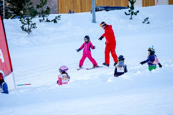 LAlpe DHuez, Francia 02.01.2019 El instructor de esquí profesional está enseñando a un niño a esquiar en un día soleado en una estación de montaña. — Foto de Stock