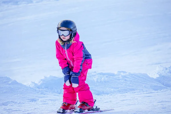 Mała dziewczynka uczy się jeździć na nartach w ośrodku narciarskim. — Zdjęcie stockowe