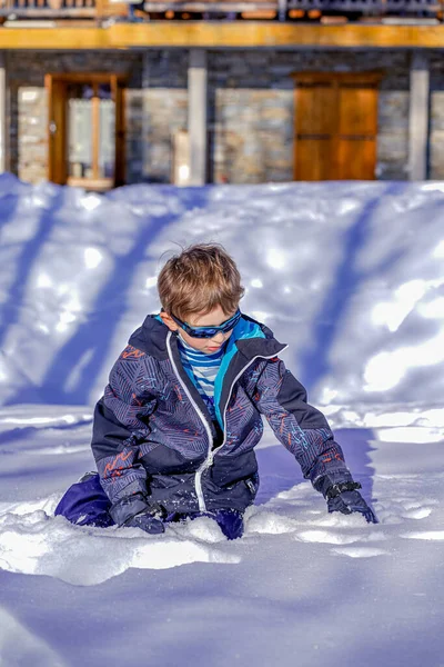 Νεαρό αγόρι με γυαλιά ηλίου που παίζει στο χιόνι — Φωτογραφία Αρχείου