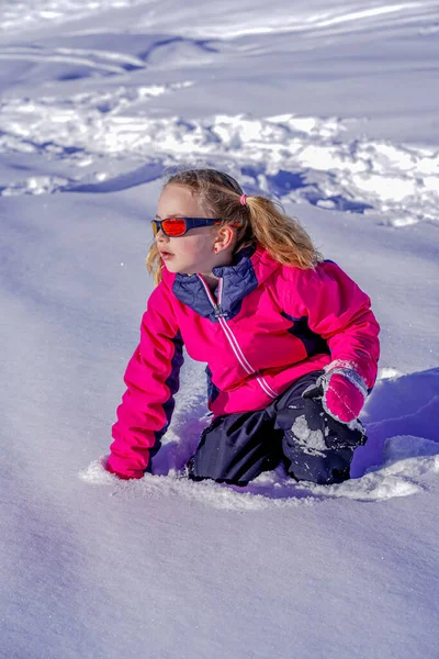 Νεαρό κορίτσι με γυαλιά ηλίου που παίζει στο χιόνι — Φωτογραφία Αρχείου