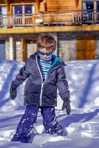 Μαλακό φόντο εστίασης. Νεαρό αγόρι με γυαλιά ηλίου που παίζει στο χιόνι — Φωτογραφία Αρχείου