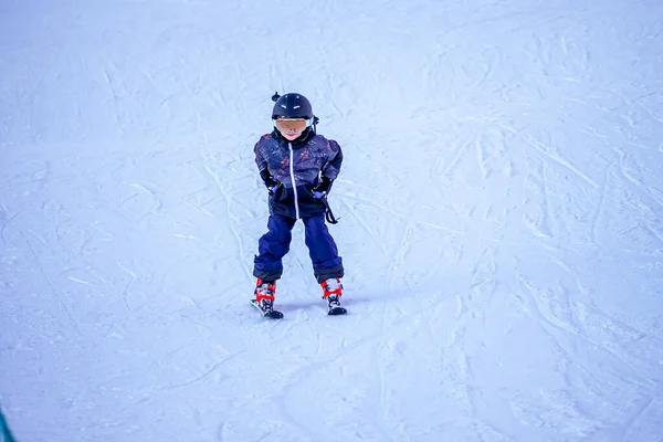 Miękkie tło ostrości. Młody chłopiec na nartach w ośrodku narciarskim. — Zdjęcie stockowe