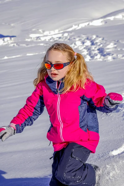 Μαλακό φόντο εστίαση.Νεαρό κορίτσι με γυαλιά ηλίου που παίζουν στο χιόνι — Φωτογραφία Αρχείου