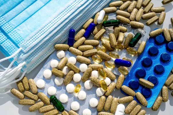 Närbild Medicinska Skyddsmasker Med Olika Piller Över Ljusgrå Bakgrund Högkvalitativt — Stockfoto