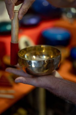 Tibet şarkı kasesinde çalan adam. Rahatlama, meditasyon ve geleneksel müzik konsepti. Yumuşak odak arkaplanı