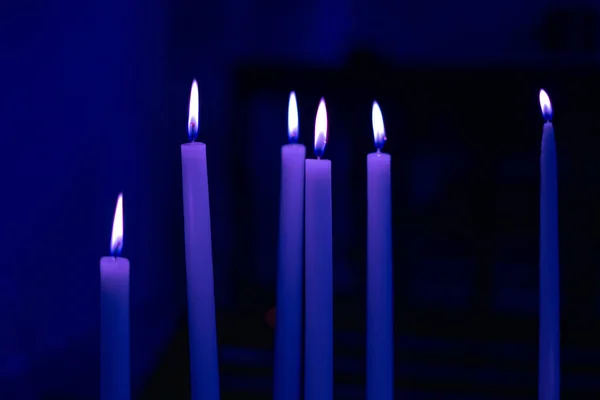 Colorful light candle flame close-up in church for religious ritual. Black background. Soft focus background — Stock Photo, Image