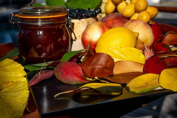 Натюрморт с виноградом, нектаринами, лимоном, джемом и осенними листьями. Осенний сезон сбора урожая. Свежие вкусные здоровые фрукты, содержат витамины, сырую пищу. Сладкий домашний джем. — стоковое фото