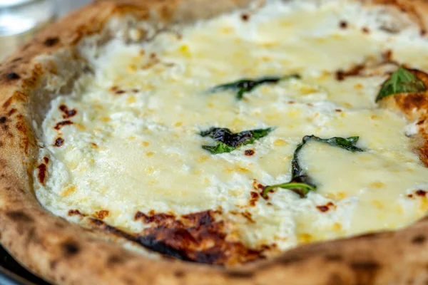 Pizza vijf kazen met spinazie op zwarte plaat op houten tafel. Selectieve focus — Stockfoto