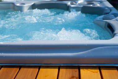 Lüks jakuzi. Kaplıcadaki sıcak küvetlerde suya yakın çekim. Mavi temiz temiz su. Spa masaj arka planı.