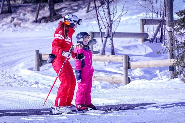 LAlpe DHuez, Francie 02.01.2019 Profesionální lyžařský instruktor učí dítě lyžovat na slunečném dni v horském středisku. — Stock fotografie
