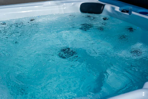 Um SPA de luxo. Closeup de água em banheiras de hidromassagem no spa. Água doce clara azul. Spa massagem fundo. — Fotografia de Stock
