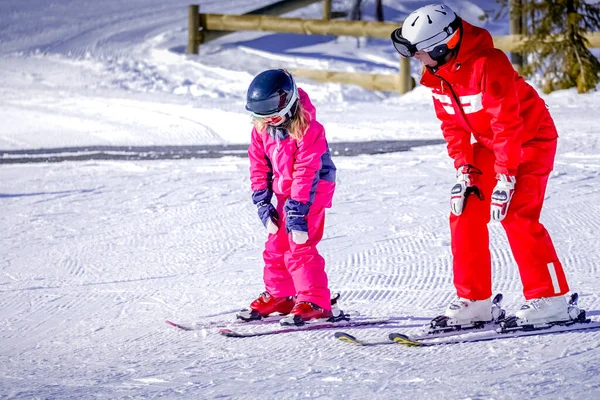 LAlpe DHuez, Francia 02.01.2019 Insegnante di sci professionista insegna a un bambino a sciare in una giornata di sole in una località di montagna. — Foto Stock