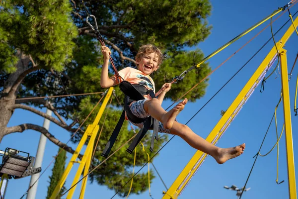 Çocuklar lastik bantlarla korunan bungee trambolinde atlarken iyi eğlenceler.. 