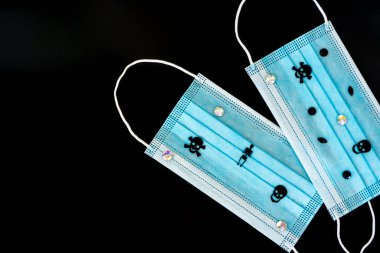 Kafatasları ve yapay elmasları olan koruyucu cerrahi maskeler. Cadılar Bayramı konsepti. Siyah arka planda izole edilmiş. Düz yatıyordu